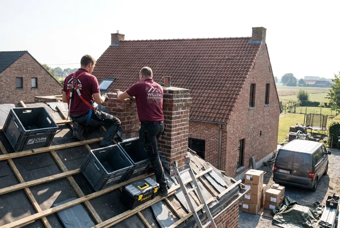 Twee dakwerkers bij de schoorsteen op een dak met nieuwe panlatten