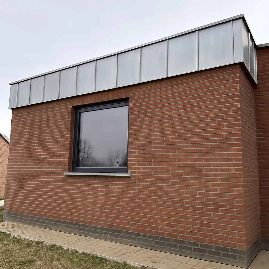 Bakstenen aanbouw met zinken dakrand